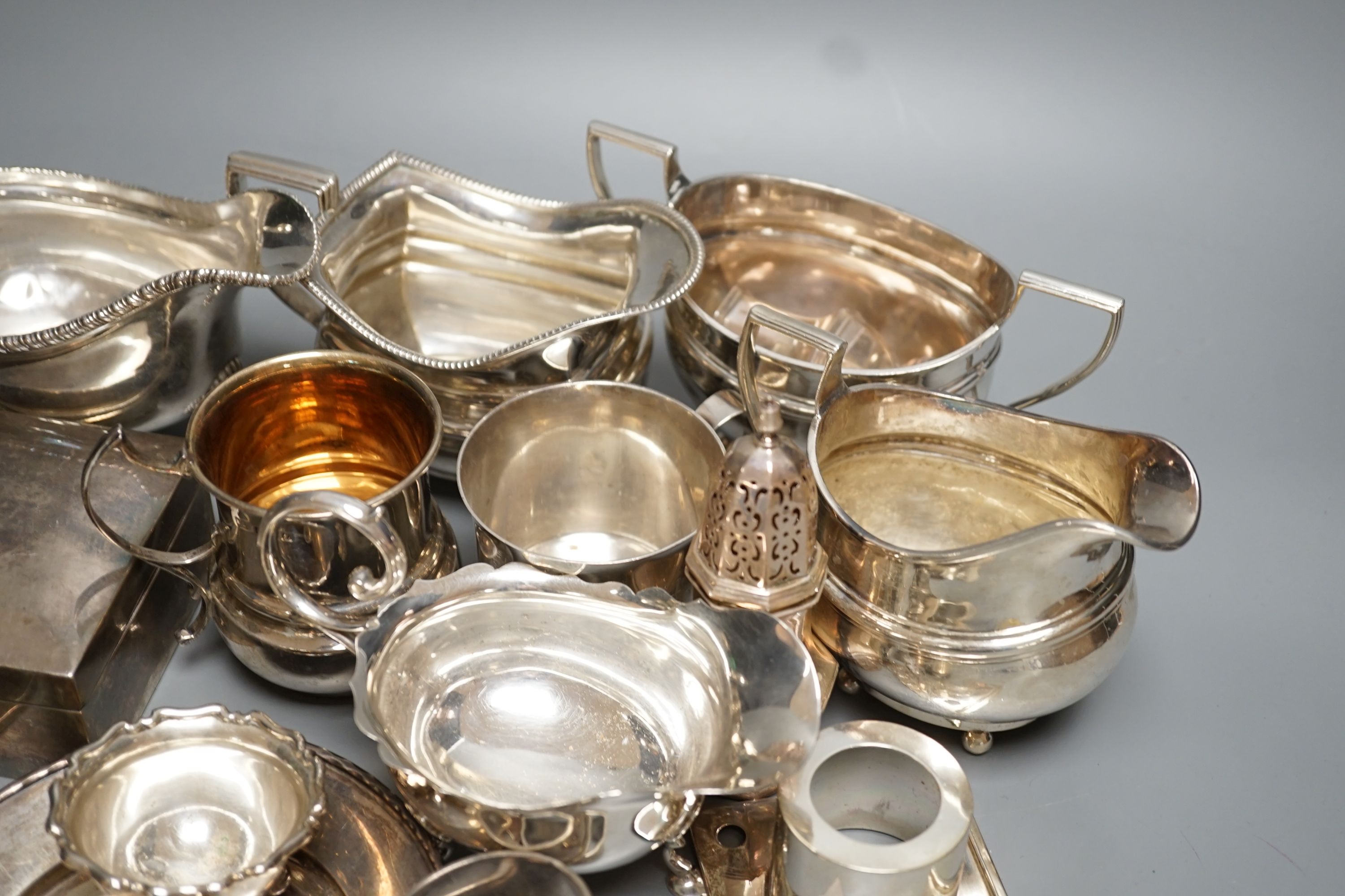 A quantity of assorted mainly 20th century sundry silver including three cream jugs, two silver sauceboats, two small mugs, pair of pepperettes, cigarette box, two match sleeves, pair of salts, seven napkin rings, two sc